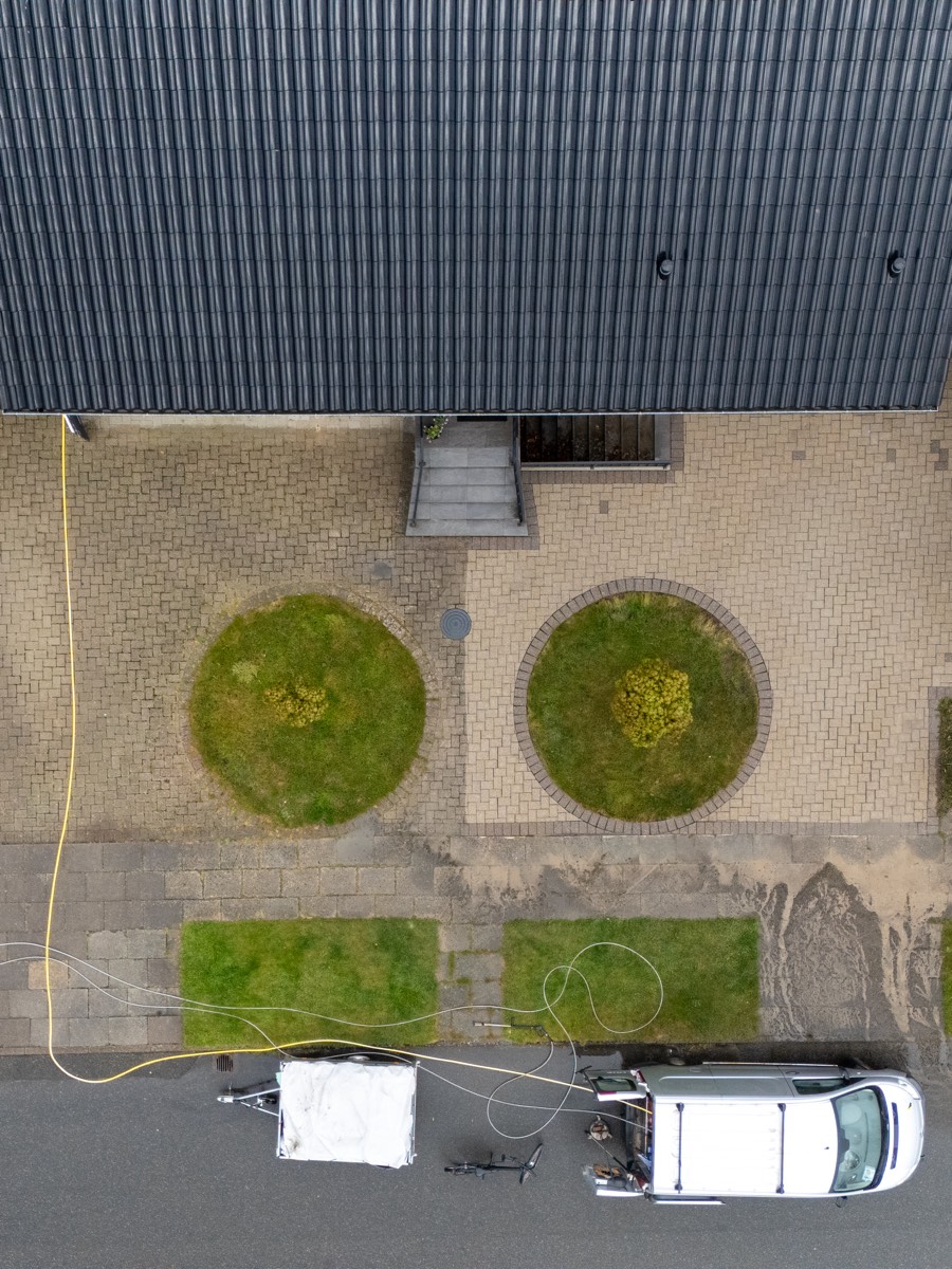 Varde Fliserens i gang med at rense en indkørsel, set fra drone
